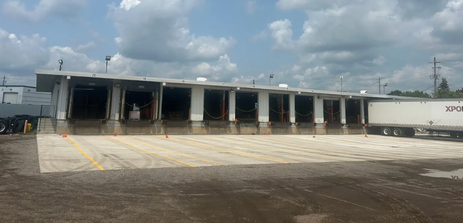 Large finished commercial concrete loading dock apron with marked truck bays at an industrial distribution facility