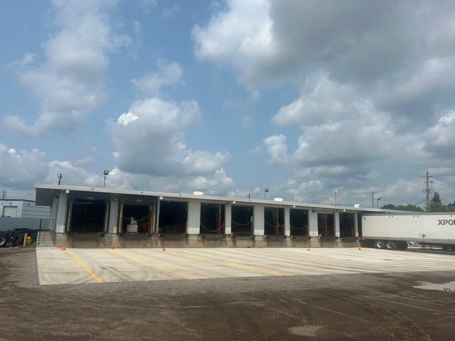 Multiple loading dock doors fronting an expansive finished commercial concrete apron